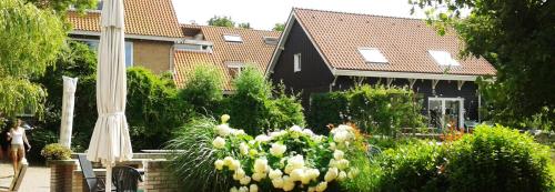 a house with a garden with flowers in front of it at Resort De Vlasschure in Wissenkerke