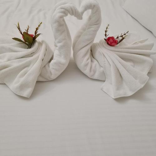 Zwei Handtuchschwäne liegen auf einem Bett in der Unterkunft Maria Tereza Bungalows in Baltschik