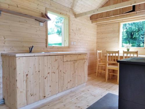 a log cabin kitchen with a counter and a table at Celoroční GLAMPING v pohodlném domečku in Výprachtice