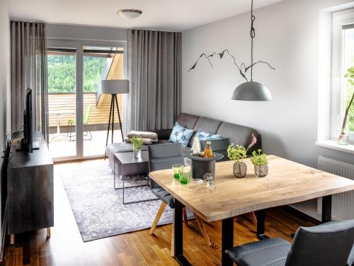 a living room with a table and a couch at der Sonnberg Alpinlodges - Apartments mit Seeblick, privater Sauna und Self Check-In in Zell am See