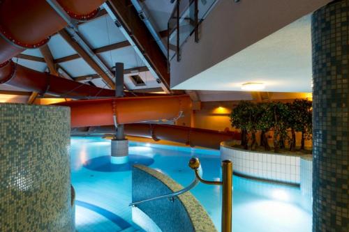 a large indoor swimming pool with a water slide at Kompleks Zagroń Istebna in Istebna