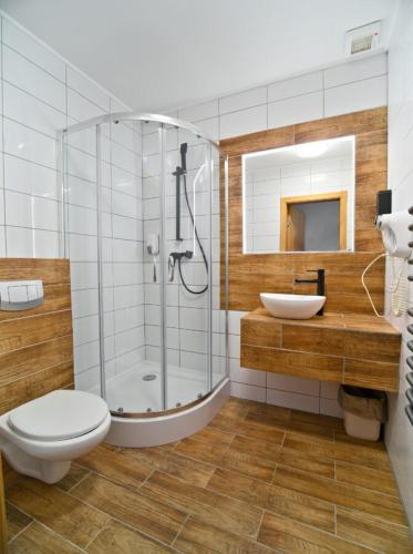 a bathroom with a shower and a toilet and a sink at Kompleks Zagroń Istebna in Istebna