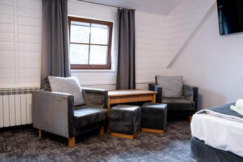 a room with two chairs and a table and a bed at Kompleks Zagroń Istebna in Istebna