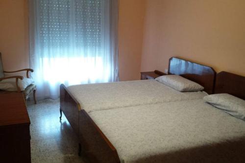 1 dormitorio con 2 camas frente a una ventana en APARTAMENTOS CAMPOMANES, en Campomanes