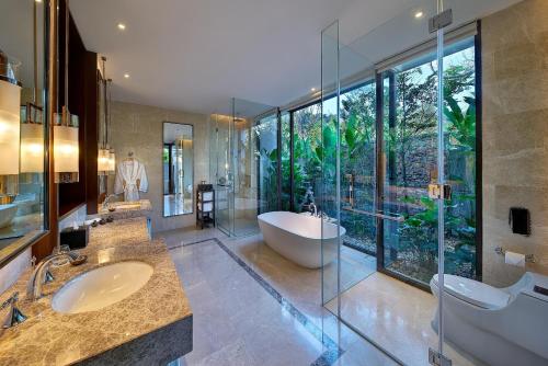 łazienka z 2 umywalkami, wanną i dużym oknem w obiekcie The Danna Langkawi - A Member of Small Luxury Hotels of the World w mieście Pantai Kok
