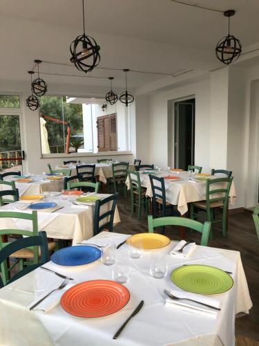 a restaurant with white tables with colorful plates on them at mammaCristina in Patti