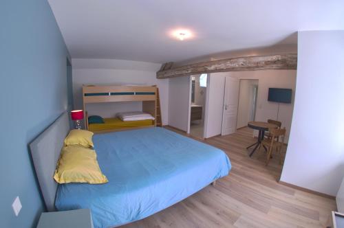 um pequeno quarto com uma cama e uma mesa em Au pré des acajous em Pertheville-Ners