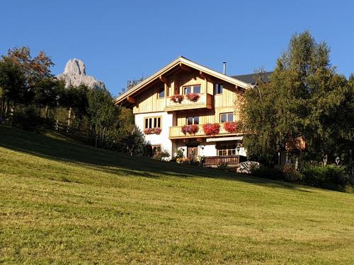 a house on a hill with a green field at Haus Berghoamat in Filzmoos
