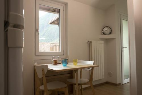 a kitchen with a table and chairs and a window at Ponte Vecchio - Grazioso nido in Vallecamonica in Darfo