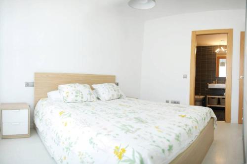 ein Schlafzimmer mit einem großen weißen Bett mit Kissen in der Unterkunft Apartamento diseño a cien metros del mar. in Torredembarra