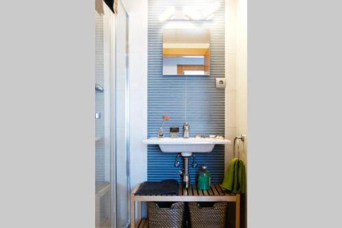 ein Badezimmer mit einem Waschbecken und einer blauen Wand in der Unterkunft Apartamento diseño a cien metros del mar. in Torredembarra
