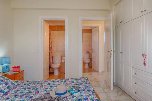 a bedroom with two toilets and a bed with a hat on it at Villa Aglaia in Corfu