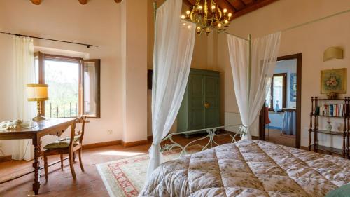 a bedroom with a bed and a desk and a window at Ca' Pellicciano 8, Emma Villas in Longiano