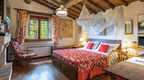 a bedroom with a bed with a red bedspread at LA CERQUA 8, Emma Villas in Gualdo Cattaneo