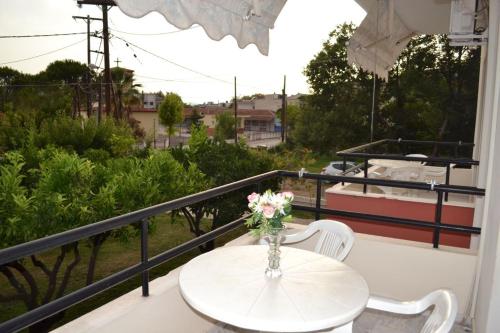 a vase of flowers on a table on a balcony at K SANTIS STUDIOS in Pefki