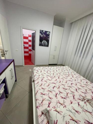 a bedroom with a bed and a red door at MEGA Apartments in Fushë-Draç