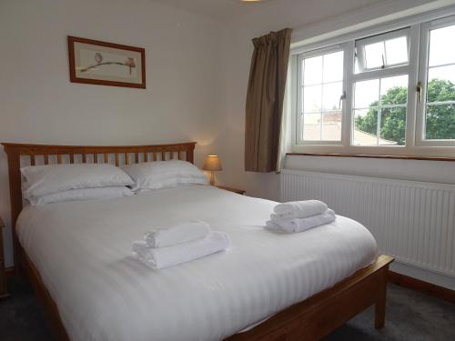 a bedroom with a bed with two towels on it at Signal Cottage at The Red House Estate in York