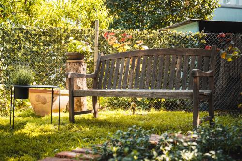 a wooden bench sitting in the grass in a yard at 4 Sterne Ferienwohnung , 65 qm in Quedlinburg