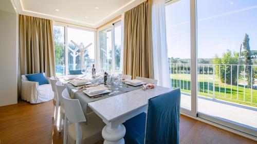 a dining room with a table and a large window at La Perla tra gli Ulivi 12, Emma Villas in San Vincenzo