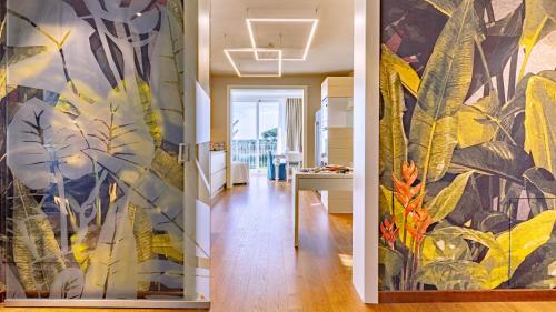 a hallway with a wall mural of plants at La Perla tra gli Ulivi 12, Emma Villas in San Vincenzo