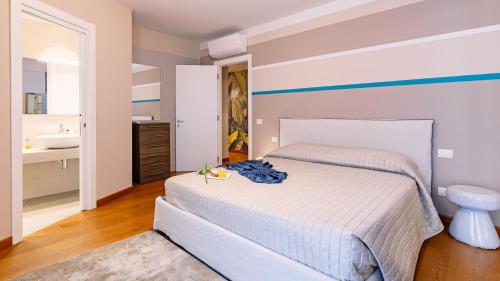 a bedroom with a bed and a bathroom with a sink at La Perla tra gli Ulivi 12, Emma Villas in San Vincenzo