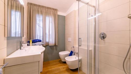 a bathroom with a sink and a shower and a toilet at La Perla tra gli Ulivi 12, Emma Villas in San Vincenzo