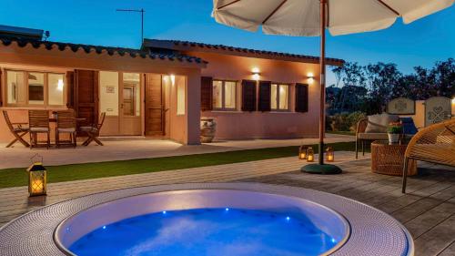 a hot tub on a deck in front of a house at Villa Gea 8, Emma Villas in Costa Rei