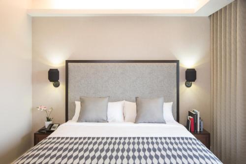 a bedroom with a large bed with a large headboard at Leon Hotel LES in New York