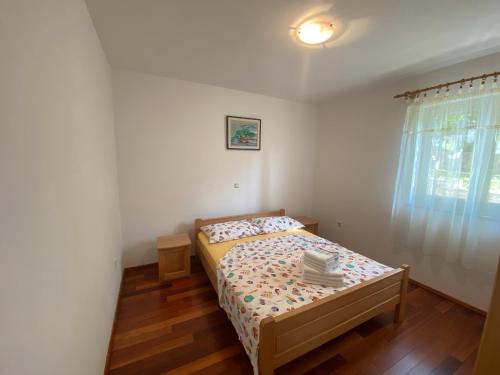 a small bedroom with a bed and a window at Apartments Malinska - apartment 1 in Malinska