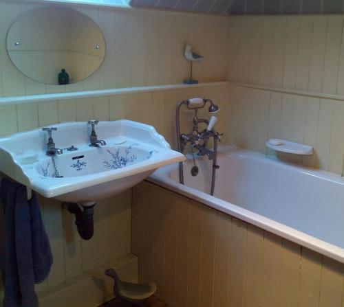 
a bathroom with a sink, toilet and bathtub at Field Farm Cottage B&B in Reading
