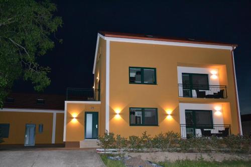 a large yellow building with lights on it at night at Apartmany u Polanských Lednice in Lednice