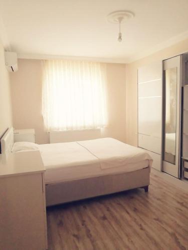 a white room with a bed and a window at Trabzon Meydan in Trabzon