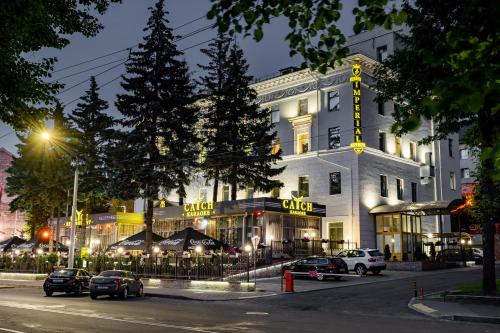 a large white building with cars parked in front of it at Imperial Palace Hotel in Minsk