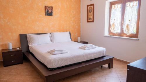 a bedroom with a bed with two towels on it at Casa L'Alzoni in San Teodoro