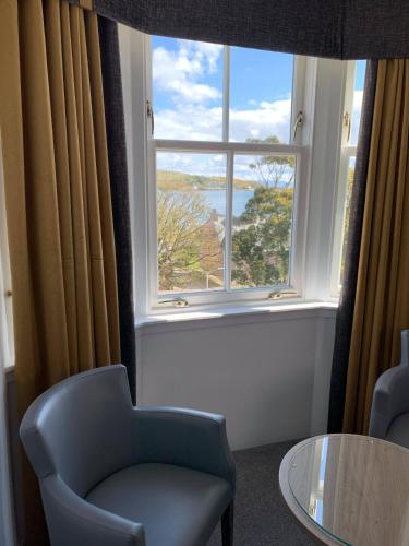 a room with a window with a chair and a table at Ardshiel Hotel in Campbeltown