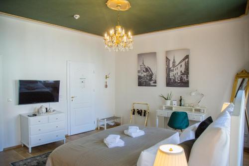 a bedroom with a bed and a chandelier at ApartOne Altstadt-Hotel in Bautzen