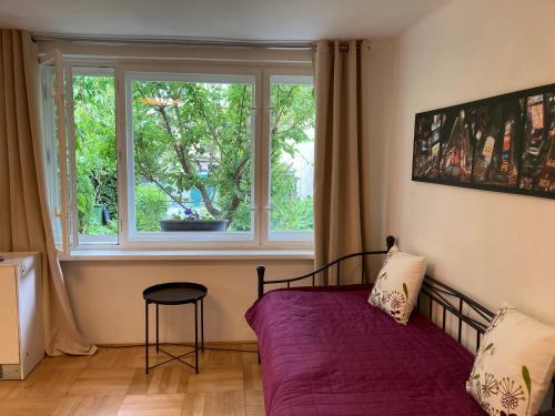 a bedroom with a purple bed and a window at Zahradní domek v Poděbradech in Poděbrady