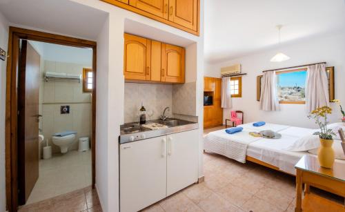 een keuken en een slaapkamer met een bed en een wastafel bij KRANA APARTMENTS in Lindos