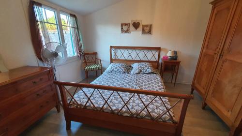 a bedroom with a bed and a dresser and a window at Entre port et plages in La Tremblade