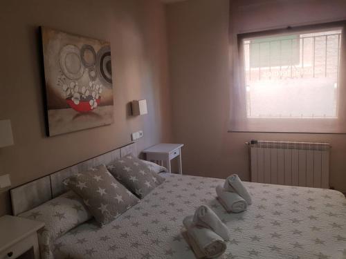 
a bed room with a white bedspread and a painting on the wall at Hostal Termes in Sitges
