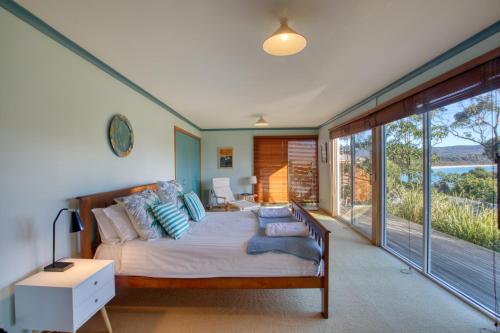 una camera con un letto e una grande finestra di Beach Side Bay Of Fires a Binalong Bay