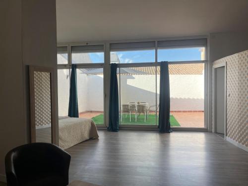 a room with a bed and a large sliding glass door at Le Grand Hôtel Molière in Pézenas