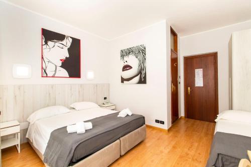 a bedroom with two beds and two posters on the wall at Hotel Cristallo Torino in Turin