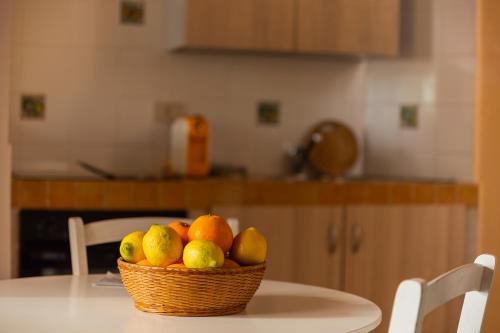 a basket of fruit on a table in a kitchen at ToviMar Apartments in Taormina