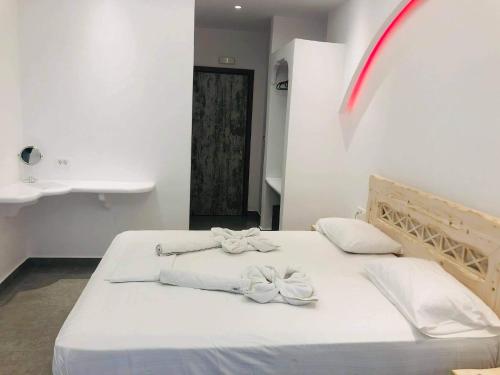 a bedroom with a bed with white sheets and bows at Cyclades Hotel in Karterados