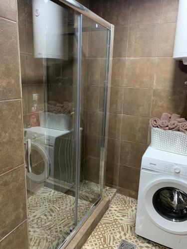 a bathroom with a washing machine and a washer at Apartmani Lunija in Gornji Milanovac