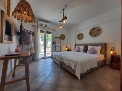 Schlafzimmer mit einem Bett, einem Tisch und einem Fenster in der Unterkunft Janakos View Apartment with Private Pool in Glinado Naxos