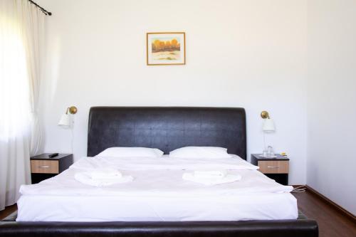 a bedroom with a large white bed with two night stands at Casa Strabunicului in Pîrteştii de Sus