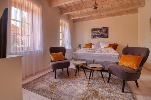 a bedroom with a bed and two chairs and a table at Manna Villa in Eger