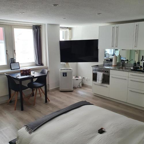a kitchen with a table and a kitchen with white cabinets at Top city center location by Airhome in Zug